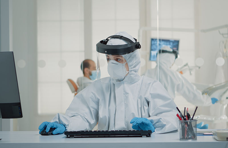 Stomatology assistant sitting at desk using computer